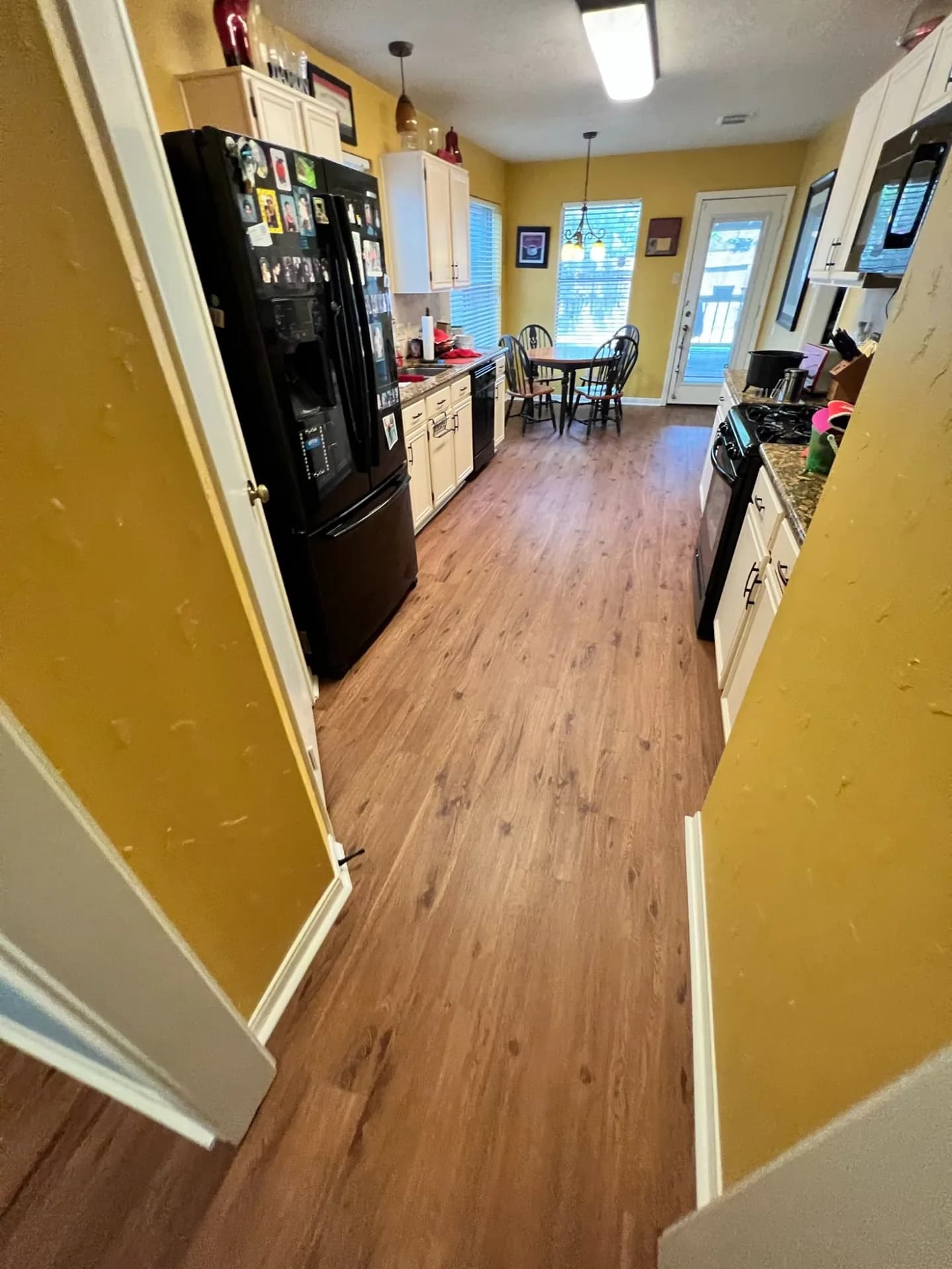 Warm walnut LVP running from a kitchen through to a breakfast area
